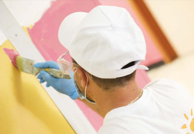 man painting wall yellow