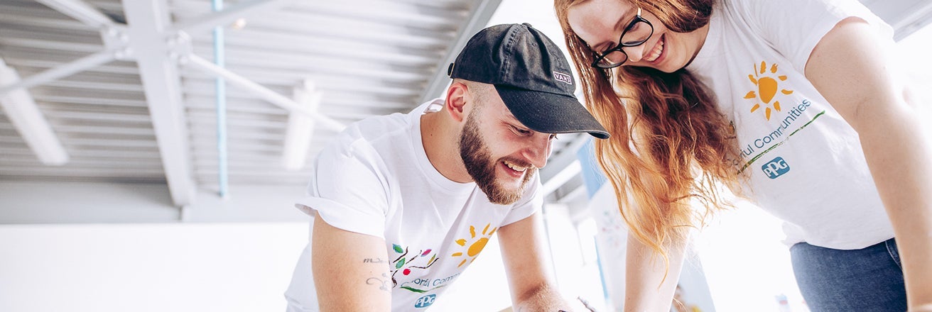 A man and a women smiling while looking down 