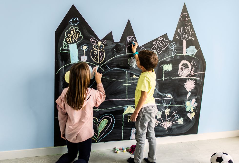 Dos niños dibujando en una pizarra