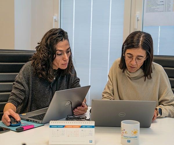 Two female PPG employees working on laptops