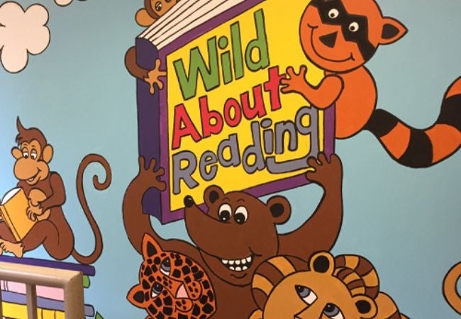 reading mural featuring monkey, lion, bear and racoon 