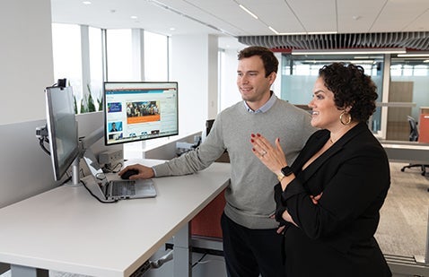 PPG employees discussing engagement whilst looking at computer screens