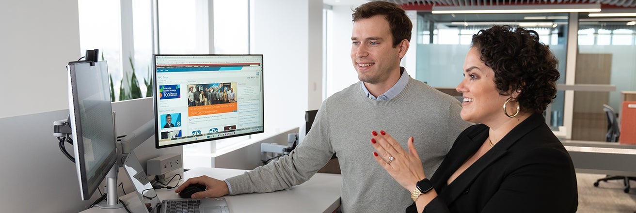 PPG employees discussing engagement whilst looking at computer screens