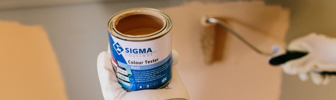 Een hand die een verfblik vasthoudt