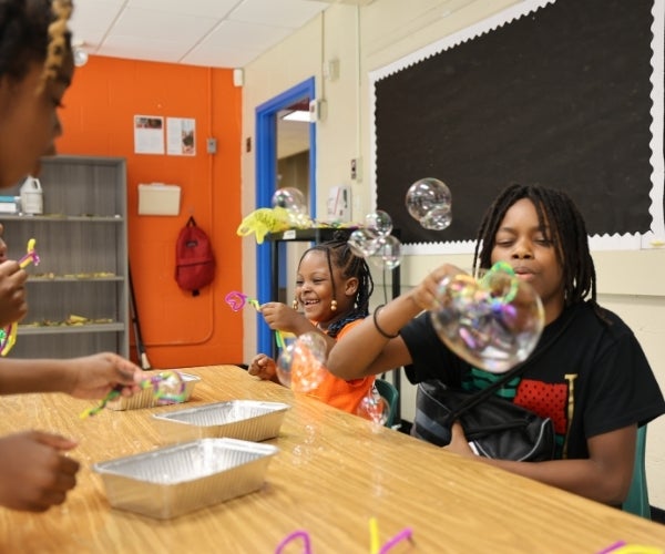 A group of children blowing bubbles