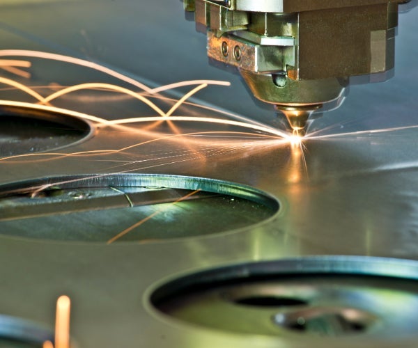 Laser cutter cutting circles out of a metal sheet