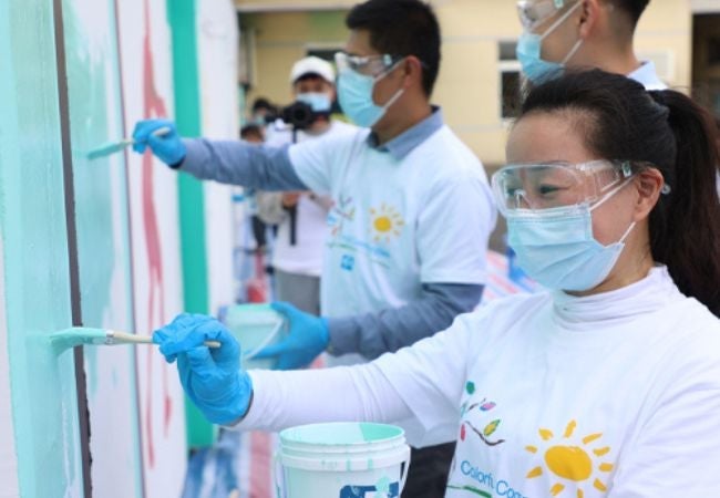 volunteers painting a mural in Shanghai, China 