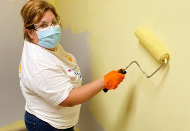 woman paint wall with yellow paint