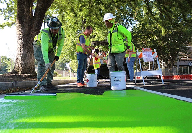A group of men painting a road