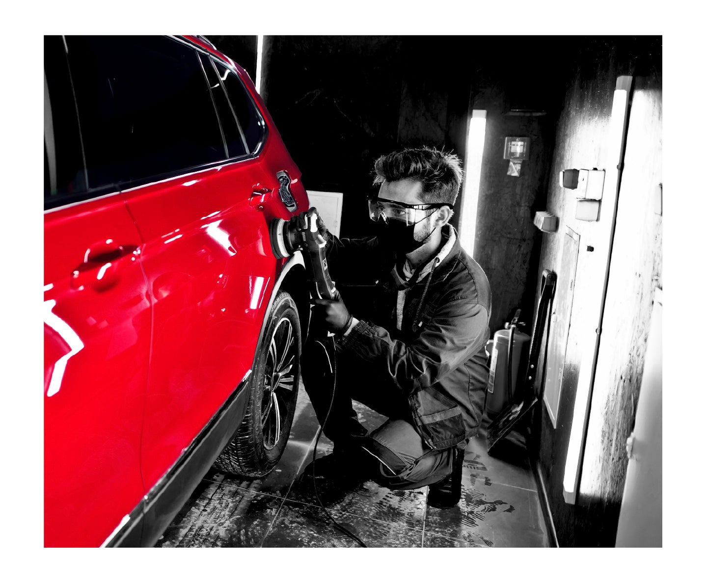 Un hombre con gafas protectoras que utiliza una máquina para pulir un automóvil