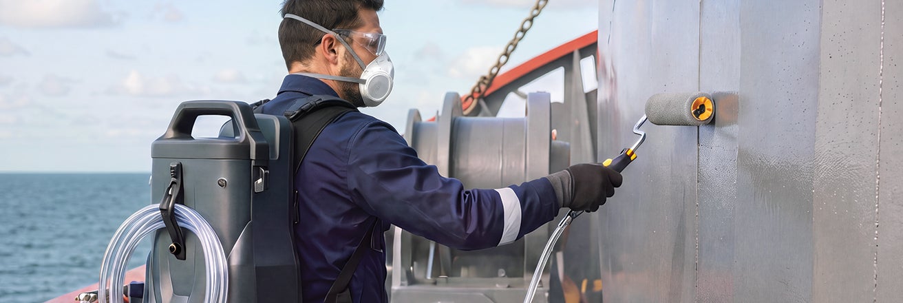 Worker using PPG Powerpack whilst coating a ship