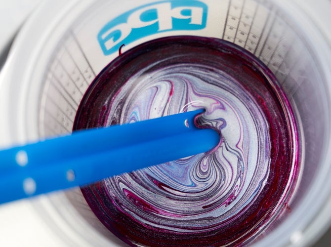 Paint being mixed in measuring cup