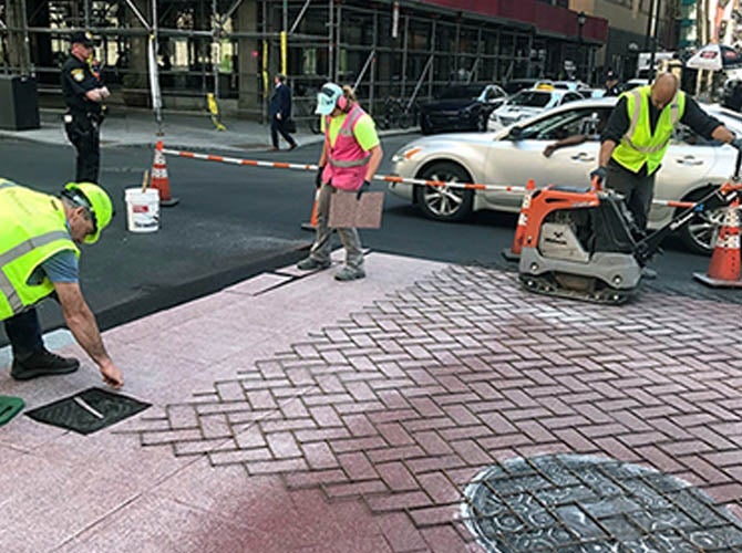 Workers applying TrafficPatternsXD brick pattern crosswalk in Philadelphia