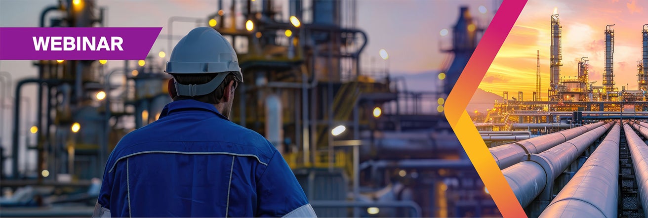 Worker overseeing refinery with pipework