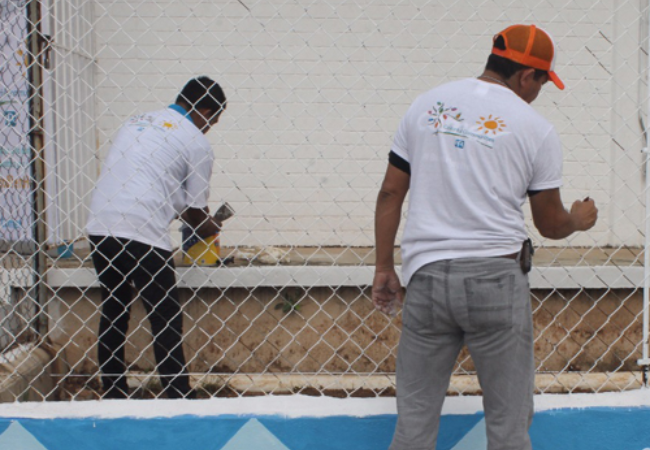 two men painting fence in Tabasco Mexico 