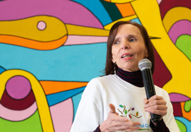 Woman speaking in front of colorful wall