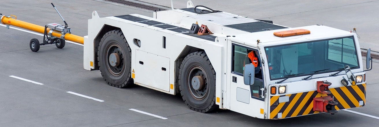Large vehicle travelling along road with white coating