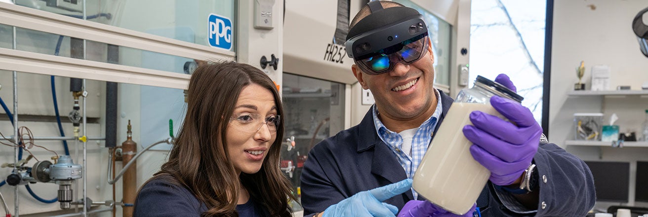 Two colleagues in laboratory examining chemicals