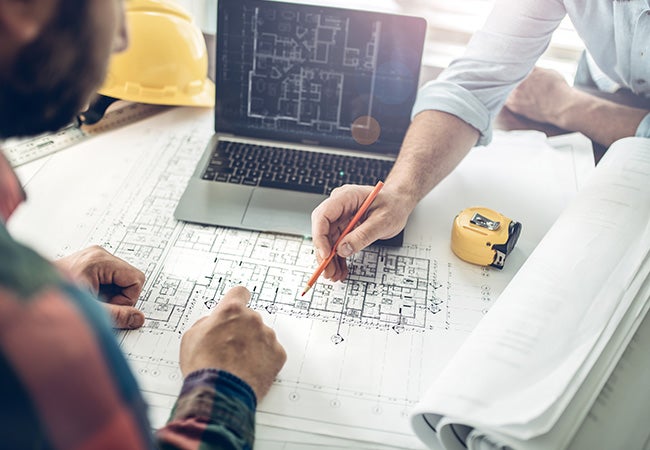 Architects looking at building scale plans