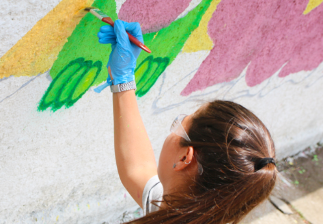 Girl Painting mural on a wall