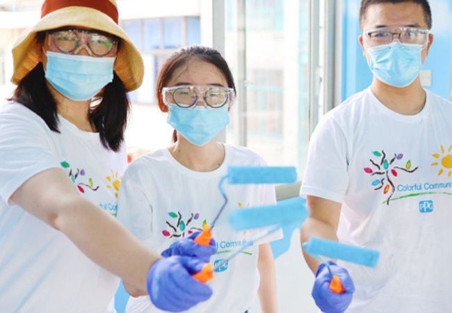 three women holding paint rollers