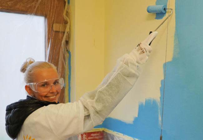 girl painting wall blue in Brno, Czech Republic 