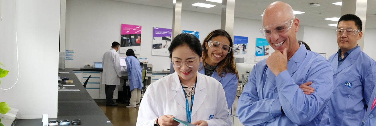 Tim Knavish in laboratory with PPG colleagues wearing PPE