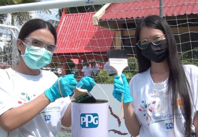 women holding paint and paint brush in Samutprakarn, Thailand