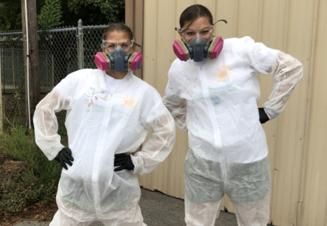 two girls posing in painters suits