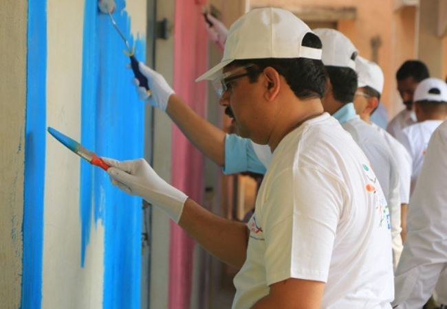 man painting wall blue in Sriperumbudur, India 