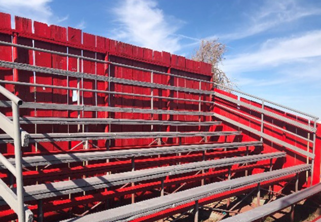 bleachers surrounded by red fence 