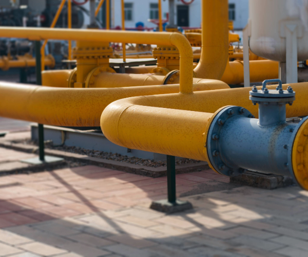 Above ground large yellow pipes connected with blue valves, bolts and nuts