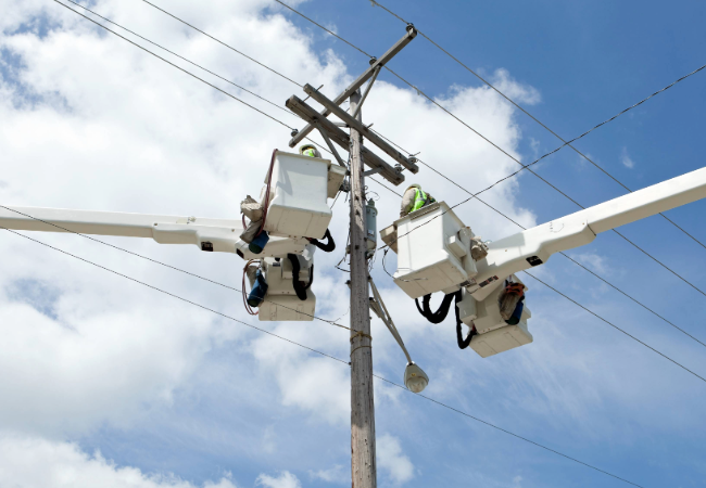 Close-up view of electrical transformers and high voltage insulators at a power substation under a clear blue sky