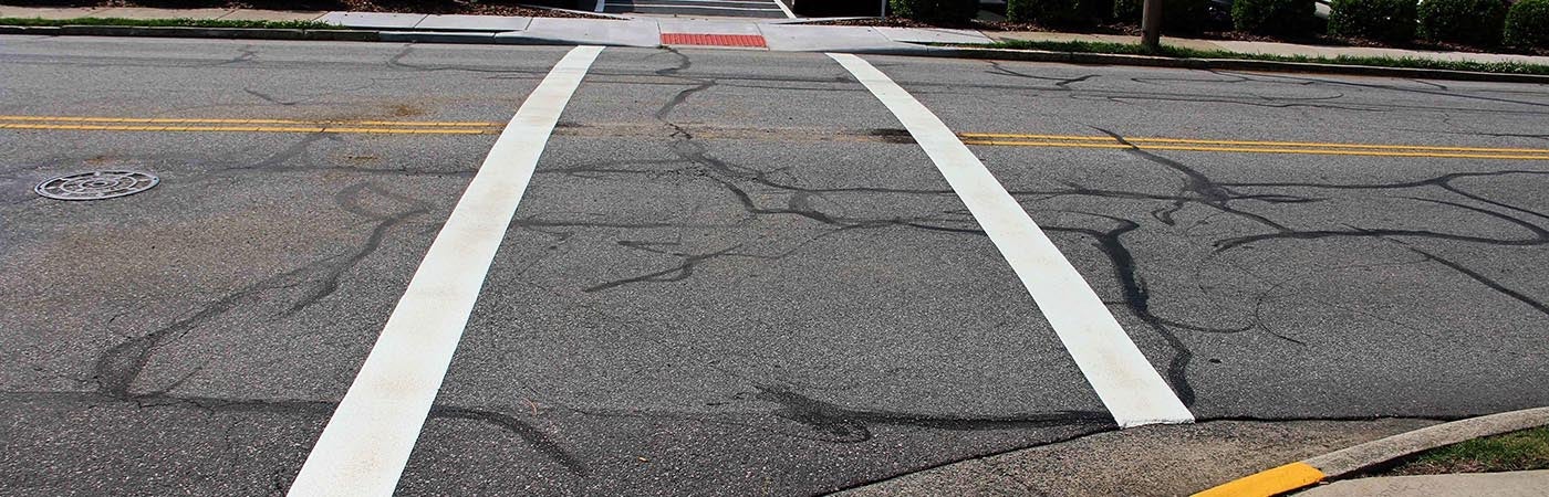 A crosswalk with straight white lines