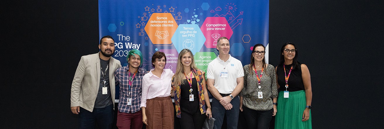 Group of PPG employees next to The PPG Way 2030 banner