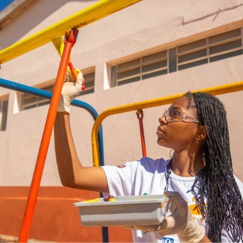 woman painting playground equipment