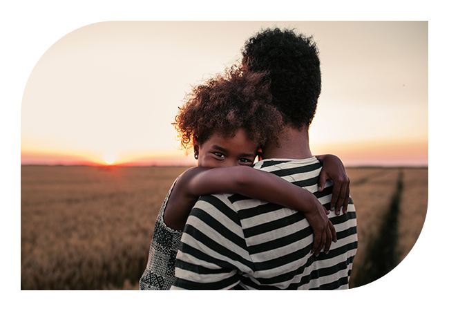 A woman hugging a child in a field