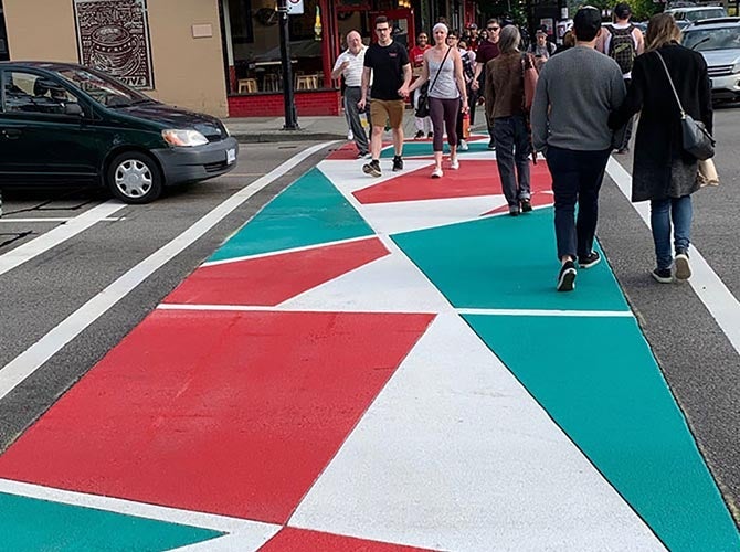 People walk across colorful crosswalks in Vancouver, CA