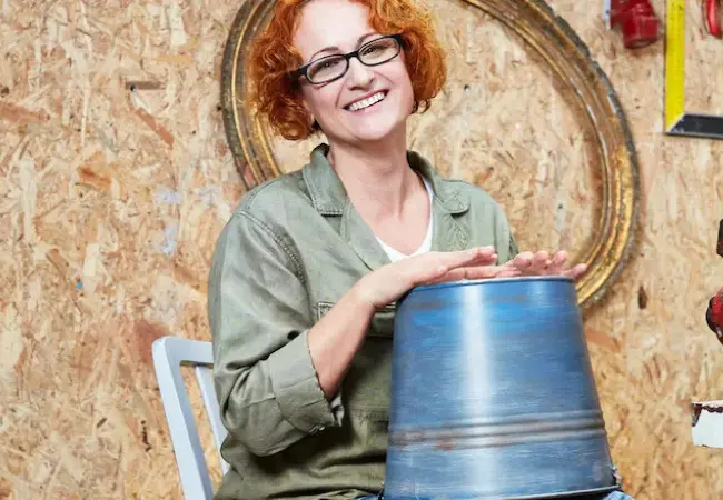 Žena sedící na židli a držící modrý sud