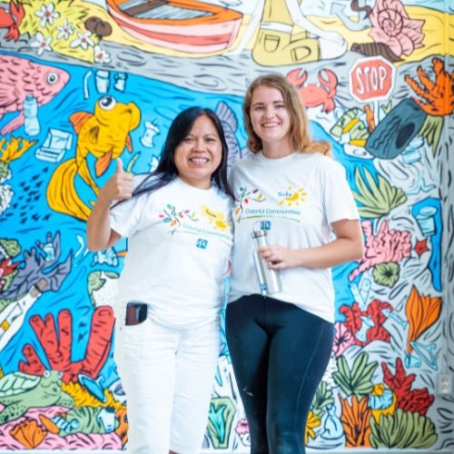 volunteers by colorful mural