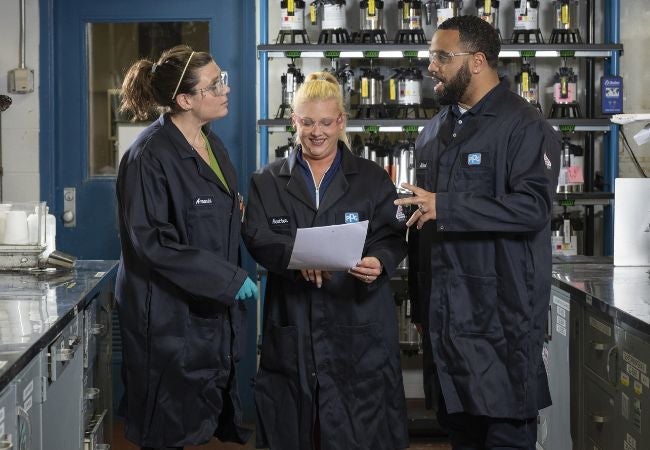 three employees looking at report