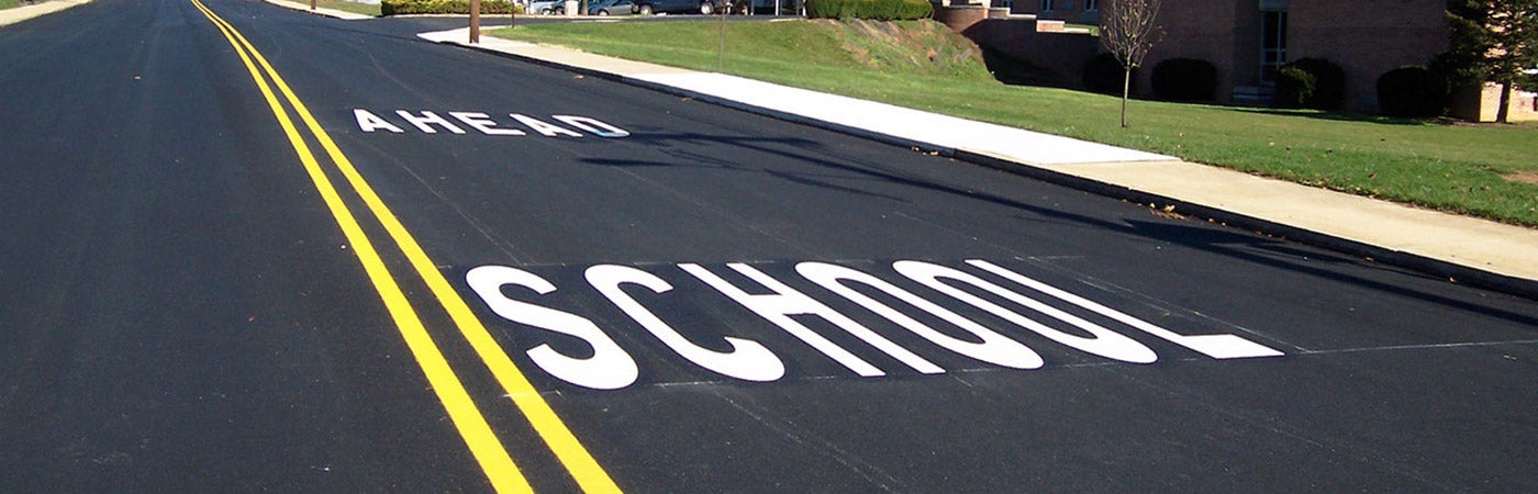 Road markings that say School Ahead