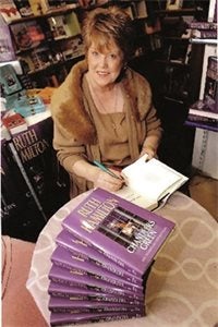 Photograph of Ruth Hamilton signing copies of her book