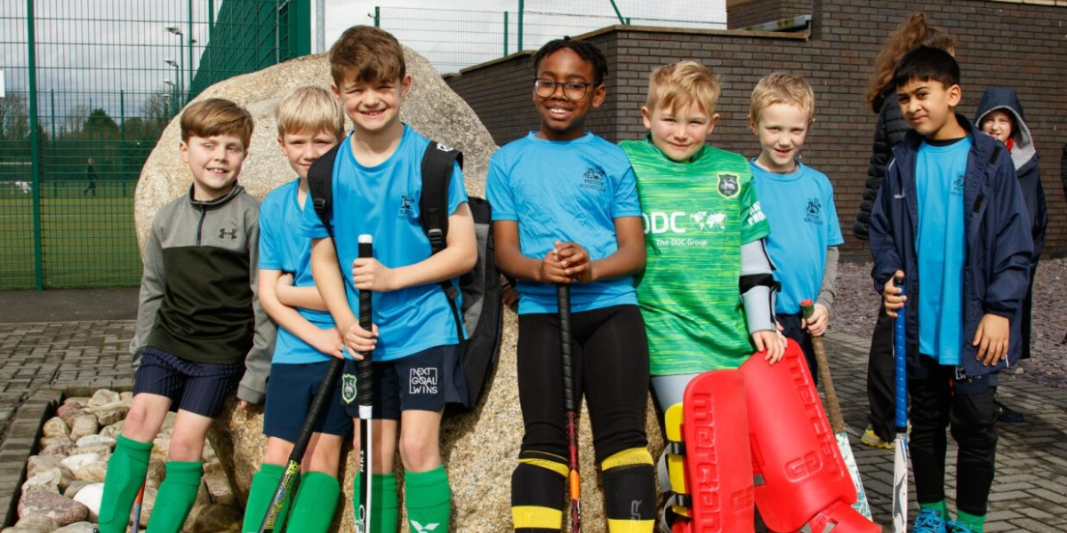 Children in a hockey team smiling for the camera