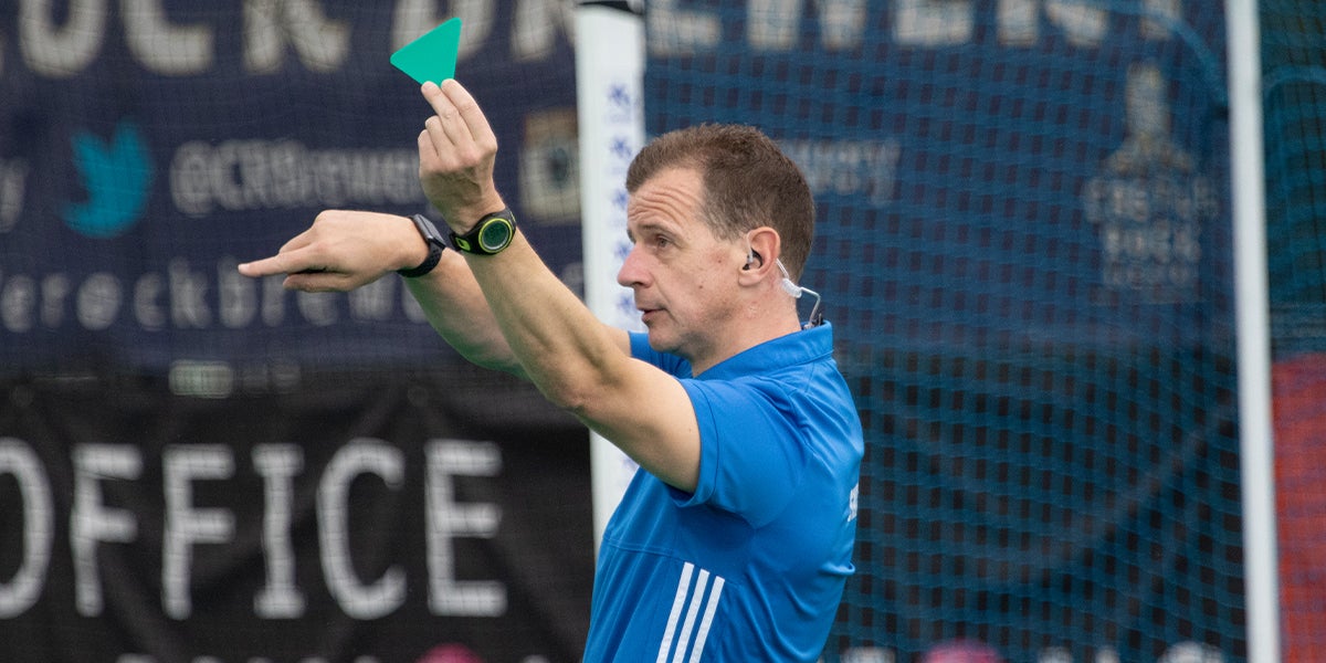 Hockey umpire issuing a green card