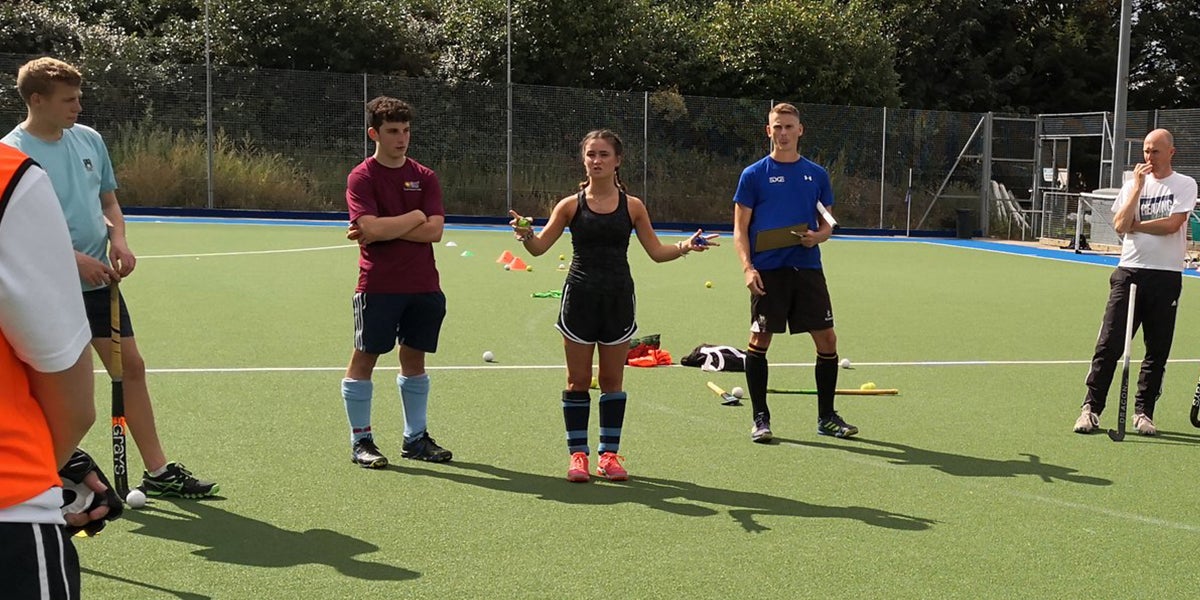 Female Coach Delivering a hockey session 