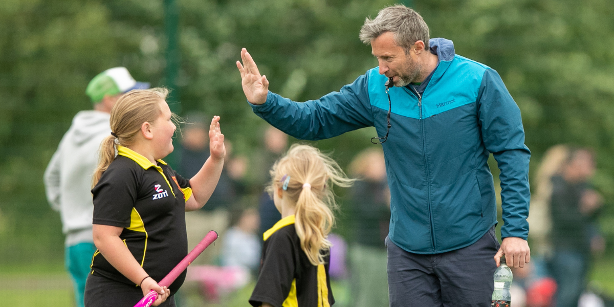 Coach high fiving young hockey player