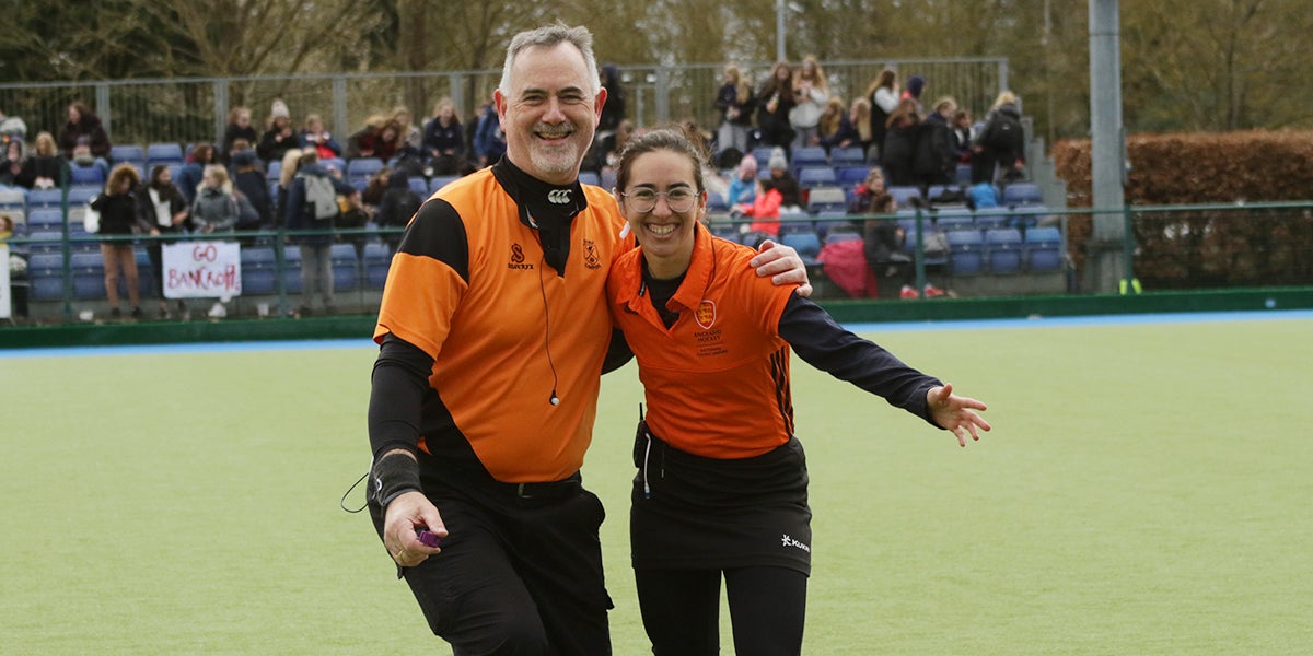 Male and female umpire hugging