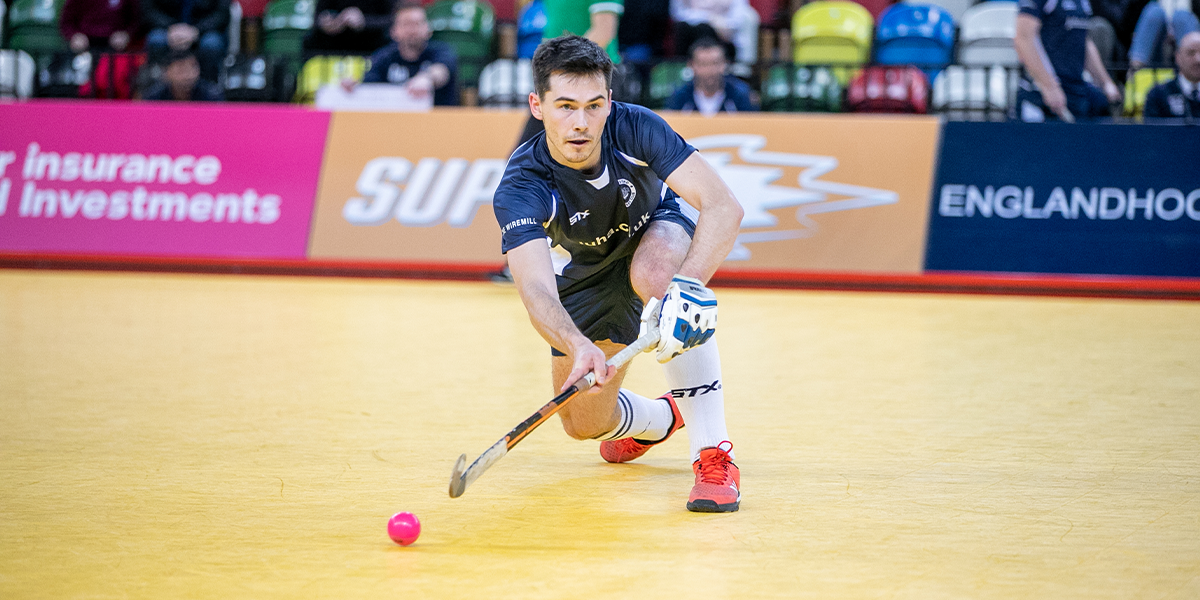 Male player making pass in Indoor Hockey 