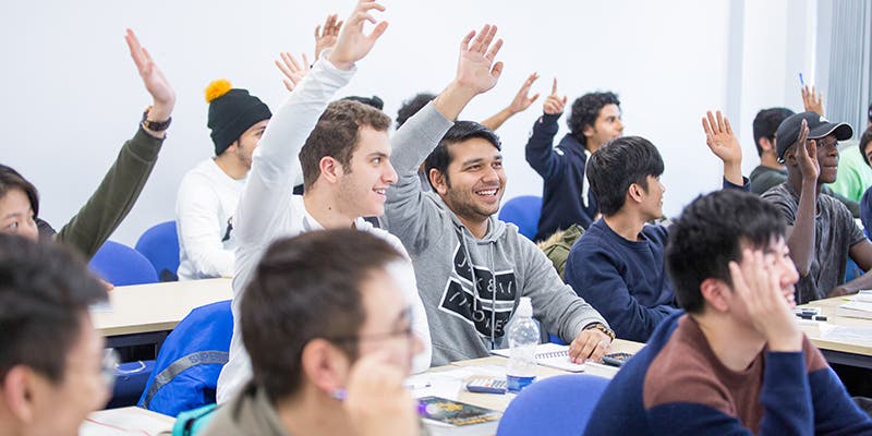 Students with raised hands in class